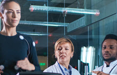 Woman on treadmill with two people watching her vitals