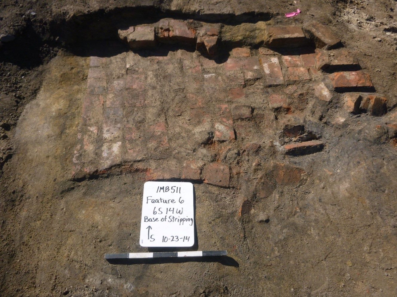 red bricks on top of soil with a white board and scale bar