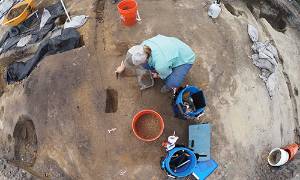 Student digging at archaeological site.