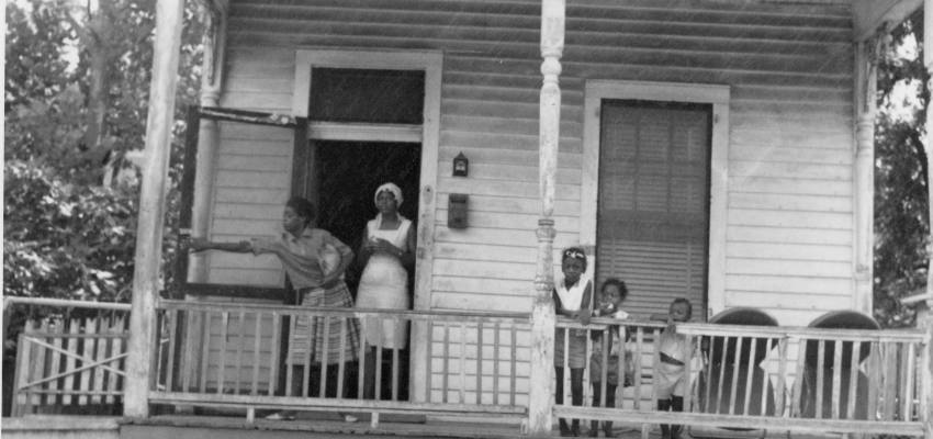 Women and children sitting on a front porch
