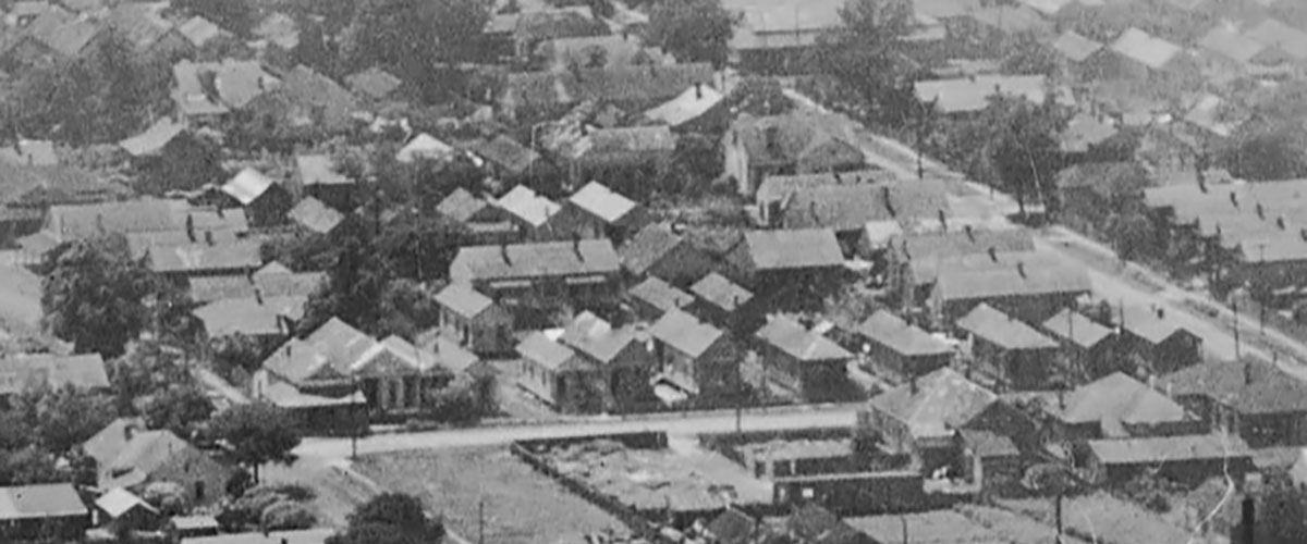 1922 aerial image showing dense housing along Our Alley between Texas and Elmira Streets. Houses can be seen directly behind the row of shotgun houses in the foreground. Image courtesy of the National Archives.