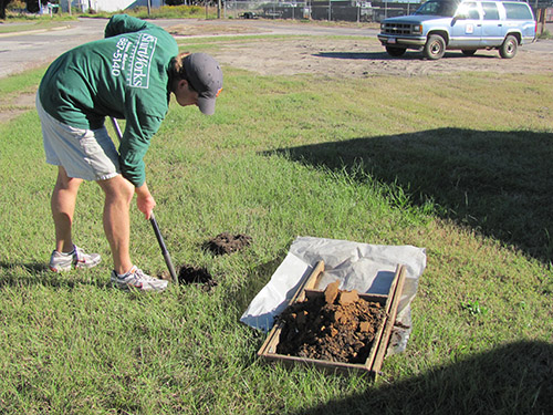 Student doing shovel testing on site.