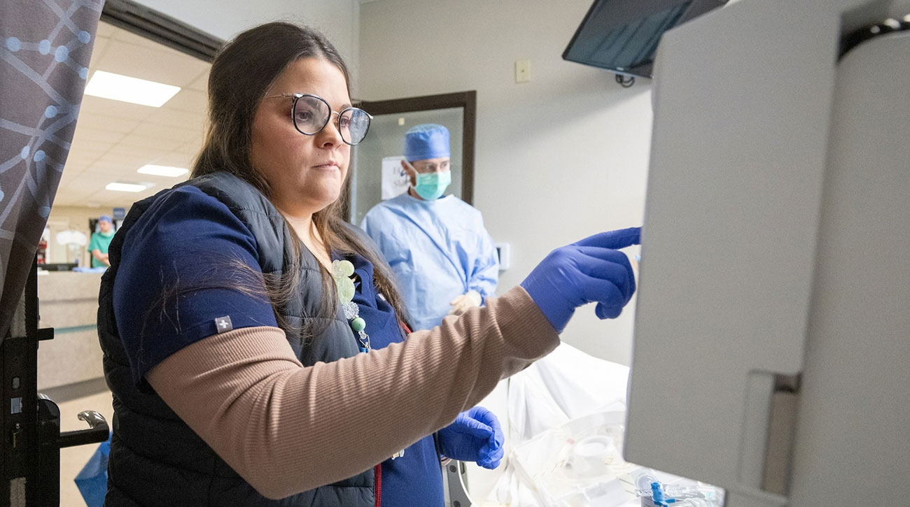 Darrian working with machine in patient's room.