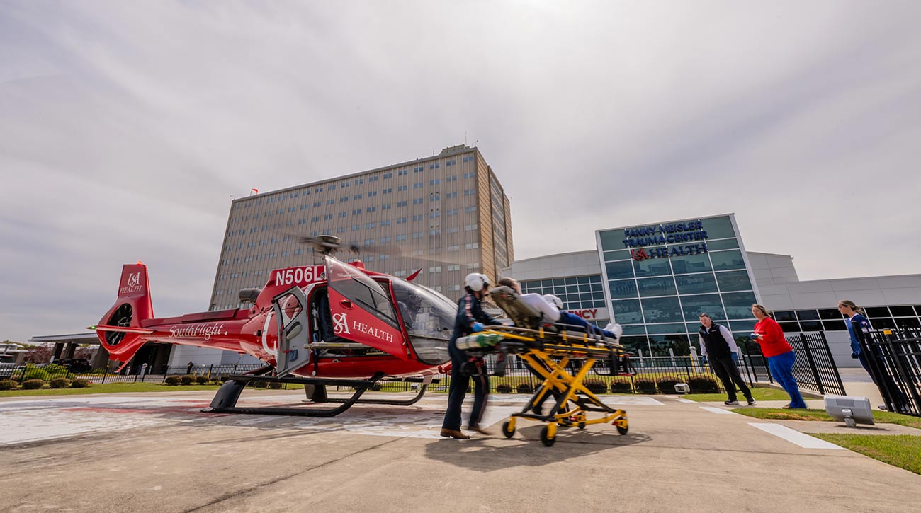 South flight rolling out patient on gurney. 